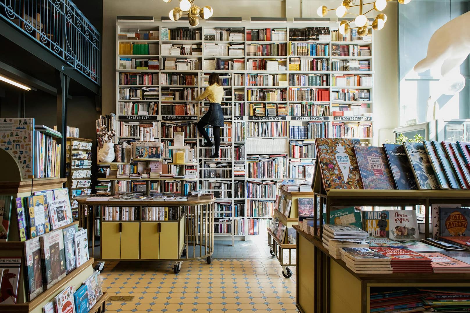 Woman climbing a ladder in a bookstore